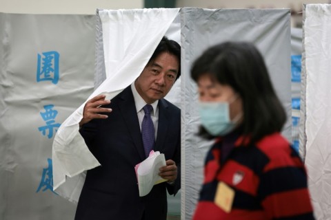 Taiwan's Vice President and presidential candidate of ruling Democratic Progressive Party (DPP) Lai Ching-te leaves a booth while holding his ballot papers