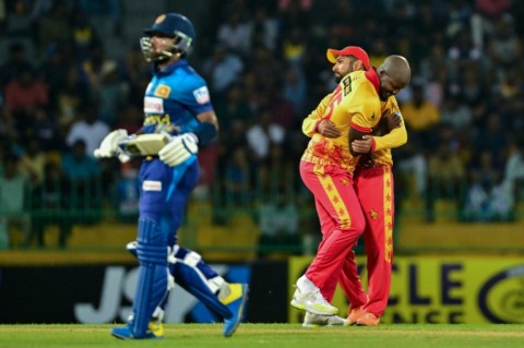 Zimbabwe's Luke Jongwe celebrates with Sikandar Raza (R) after taking the wicket of Sri Lanka's Kusal Mendis (L) during the second T20 between Sri Lanka and Zimbabwe