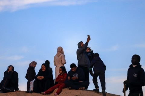 In Rafah, the southern Gaza Strip, displaced Palestinians attempt to get a signal with embedded SIM cards that allow them to get around local telecom disruptions during the Israel-Hamas war