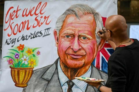 An artist finishes off a painting wishing Britain's King Charles III a speedy recovery