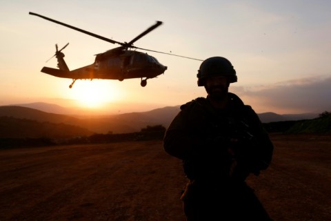 An Israeli soldier looks on as a helicopter takes off during a military exercise in Upper Galilee near the Lebanon border on February 7, 2024