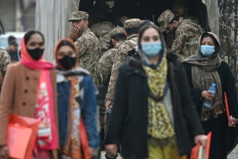 Pakistan army personnel watcs as election officials arrive at a polling station in Lahore