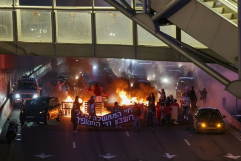 Supporters and families of Israeli hostages held in Gaza block the Ayalon highway in Tel Aviv during a protest calling for their release 