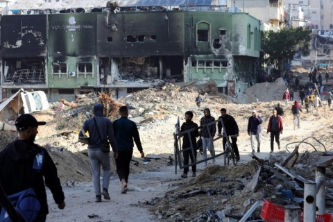 People walk along a street ravaged by Israeli strikes in the Rimal neighbourhood of Gaza City, in northern Gaza