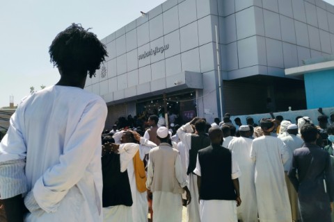 Sudanese in the eastern city of Kassala queue on February 18, 2024 outside the Sudani telecommunications company to get SIM cards from the only provider still functioning 