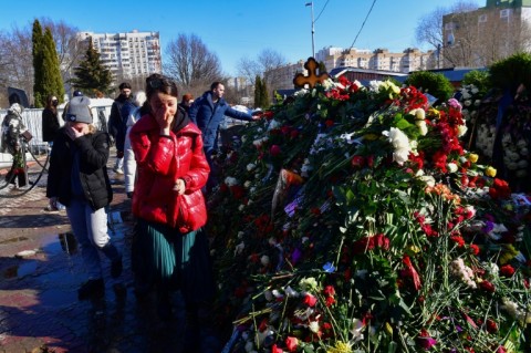 Alexei Navalny's grave was covered in a stack of flowers after thousands of mourners laid roses and carnations.