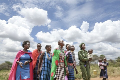 Sharon Mumbi (2nd L), 21, a member of Team Lioness is greeted by singing relatives as she arrives at her parents' home