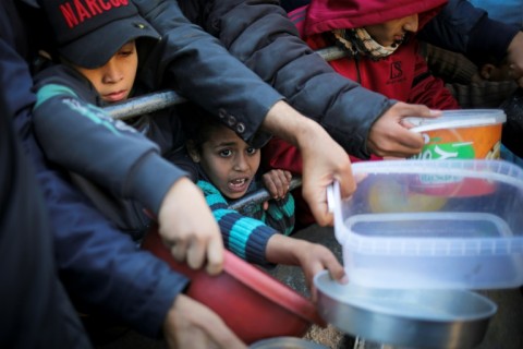 Displaced Palestinians are given food donated by a charity on the first evening of Ramadan in Rafah