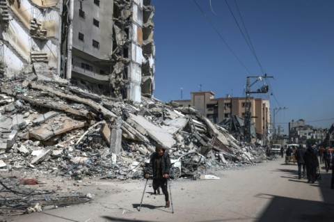 Palestinians near the rubble of a destroyed building in the southern Gaza Strip on March 12, 2024