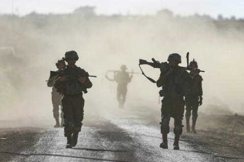 Israeli soldiers walk near the border with Gaza in southern Israel on March 12, 2024