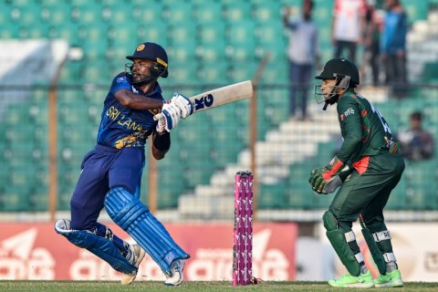 Sri Lanka's Janith Liyanage plays a shot as Bangladesh's Mushfiqur Rahim (R) watches during the first one-day international