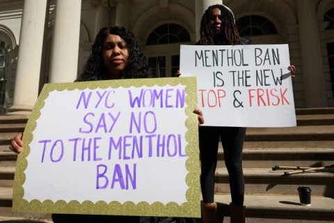 Two people hold signs at a protest against a ban on menthol cigarettes in March 2023