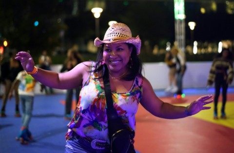 A woman celebrates as she roller skates during a listening party for Beyonce's new album "Cowboy Carter" at an outdoor roller skating rink in Houston, Texas