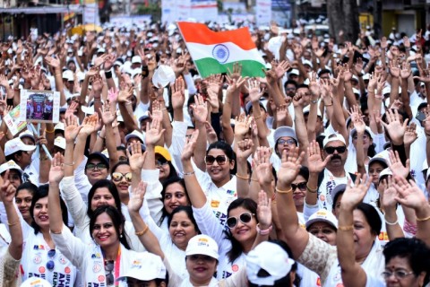 People wave India's national flag as they take part in 'Ahimsa Run' (nonviolence run) during a campaign to create awareness for citizens to vote, ahead of the country's upcoming national elections 