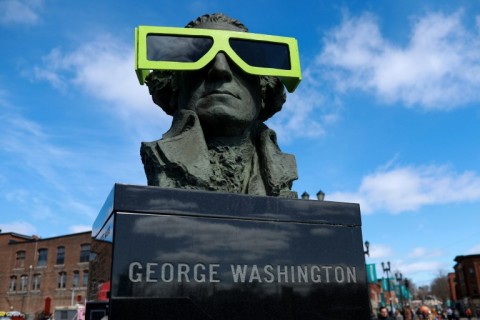 Eclipse glasses are worn by a statue of George Washington on April 07, 2024, in Houlton, Maine