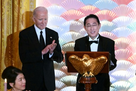 US President Joe Biden applauds as Japanese Prime Minister Fumio Kishida speaks during a State Dinner in the East Room of the White House in Washington, DC, April 10, 2024.