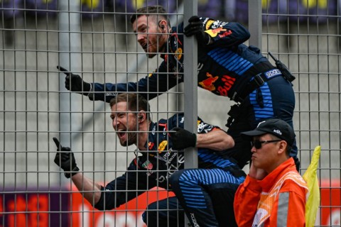 Red Bull team members celebrate on the pit wall as Max Verstappen wins