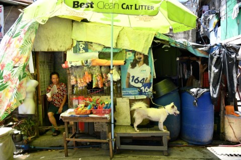 Shopkeeper Richel Mangampo sits at the door of her house