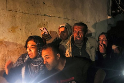 Family members gather around a wounded relative as civil defence teams help rescue victims from a home struck by Israeli bombardment in Rafah