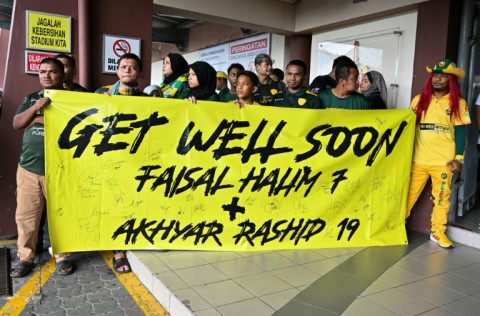 Fans hold a banner supporting injured footballers before the start of the Malaysia Super League match between Polis DiRaja Malaysia (PDRM) FC and Kedah