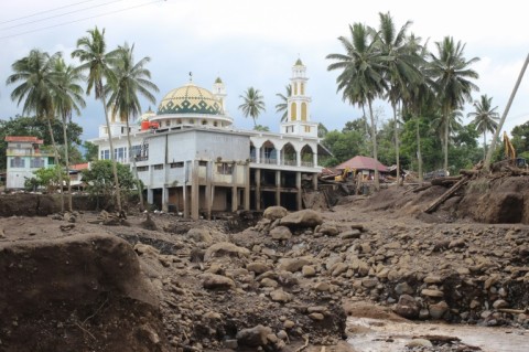 Hours of heavy rain caused large volcanic rocks to roll down one of Indonesia's most active volcanos into two of the worst-hit districts on Sumatra island