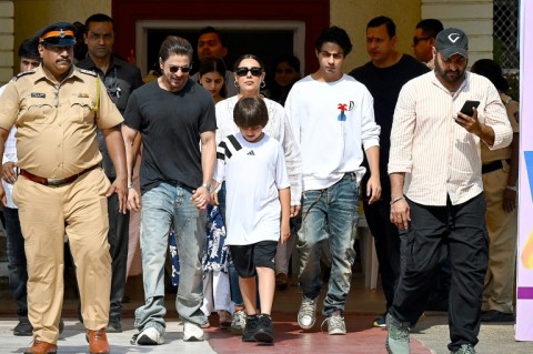 Bollywood actor Shah Rukh Khan (4L) along with his family leaves a polling booth after casting his ballot vote in Mumbai