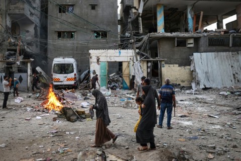 Palestinians look at the rubble of a family house that was hit in Israeli bombardment in Rafah in southern Gaza