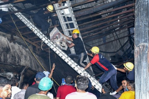 Rescue workers carry a victim after a fire broke out at an amusement park facility in Rajkot, in India's Gujarat state