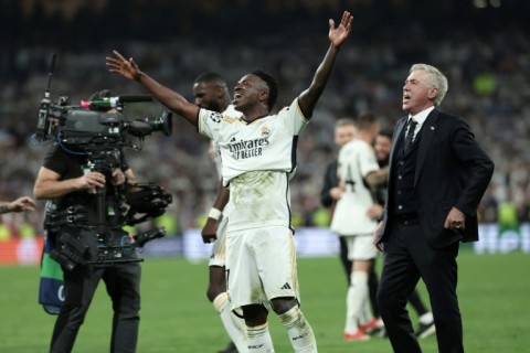 Real Madrid's Italian coach Carlo Ancelotti (R) and Brazilian forward Vinicius Junior (C) are adding to Madrid's trophy cabinet