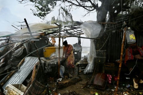 A man carries a child as he walks towards a shelter: cyclones have killed hundreds of thousands of people in Bangladesh in recent decades, but better forecasting and more effective evacuation planning have dramatically reduced the death toll