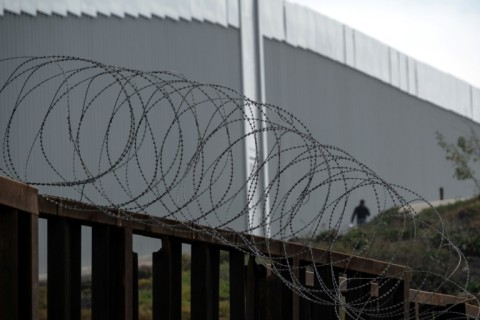 A man crosses the Mexican-US border though a gap in the fence -- part of a migration wave that will pose a major challenge to Mexico's next president 