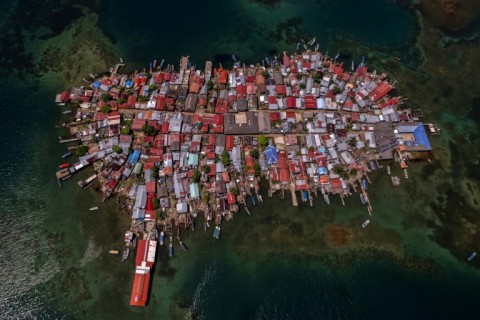 On the island -- the size of five football fields -- the community lived in rudimentary dirt-floor houses crammed together, some jutting out into the sea on stilts