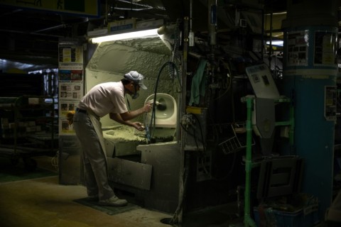 A staff member makes a toilet at a factory of Japanese toilet manufacturer TOTO in the city of Kitakyushu, Fukuoka Prefecture