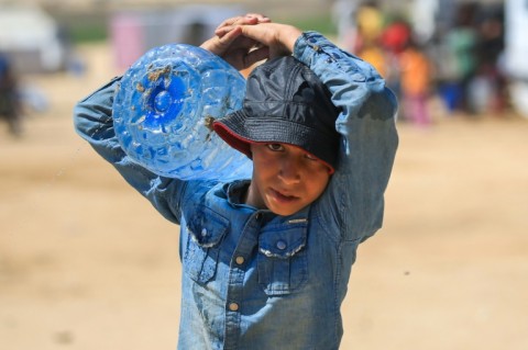 A Palestinian boy carries water in Rafah, where Israel has pressed its assault despite international concern for the civilians sheltering there