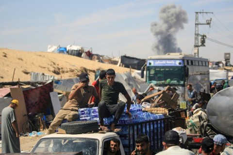 Smoke billows following Israeli bombardment as displaced Palestinians move in Rafah in the southern Gaza Strip