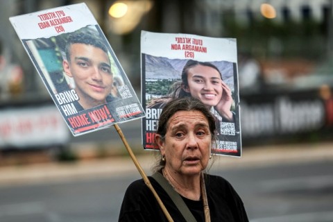 A woman holds signs with pictures of Noa Argamani and another hostage held by Palestinian militants in Gaza during a demonstration for their release, in Tel Aviv in April 2024