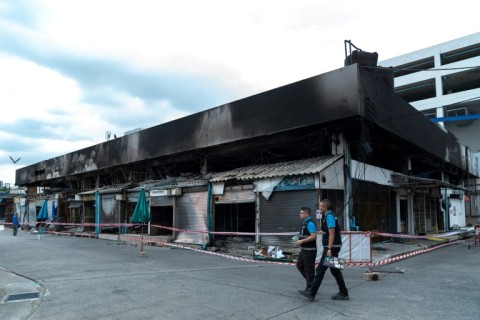 Forensics officers survey the area after a fire at a pet market next to Chatuchak market in Bangkok