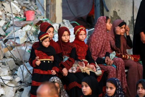 Palestinians, some in traditional embroidered dresses, gather on Eid al-Adha in southern Gaza's Khan Yunis city