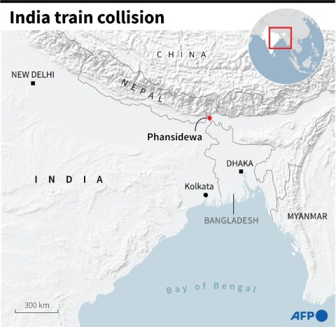 People look on at the site of a collision between an express passenger train and a goods train in India's West Bangal state 