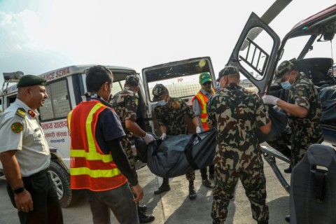 Nepalese army personnel move frozen corpses retrieved from Everest into an ambulance for their eventual cremation