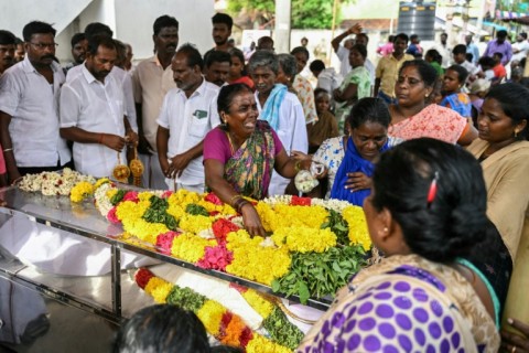 A relative weeps next to the dead body of a victim who died after consuming toxic illegal alcohol in Kallakurichi district of India's Tamil Nadu state 