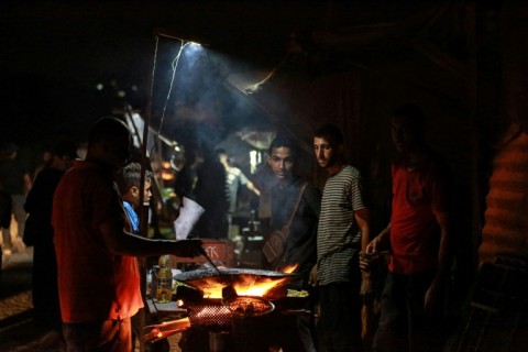 Food vendors along a street with no lights in central Gaza, where power supply and other basics have been limited by the war