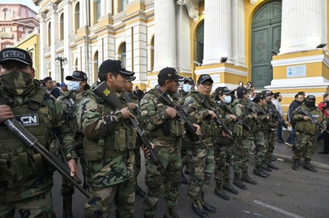 Police officers stand guard at Plaza Murillo in La Paz after soldiers and tanks took up position in front of government buildings