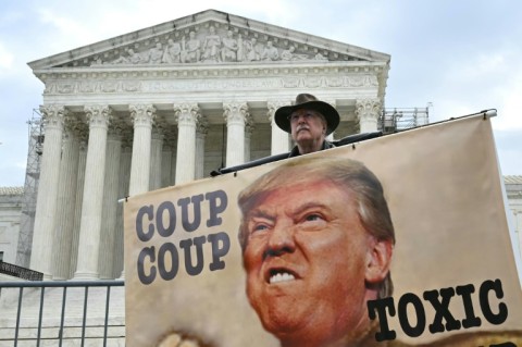 A demonstrator outside the Supreme Court during the April immunity hearing