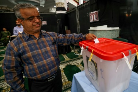 An Iranian man casts his ballot at a polling station in Tehran -- turnout for the runoff was 49.8 percent, according to Iran's electoral authority