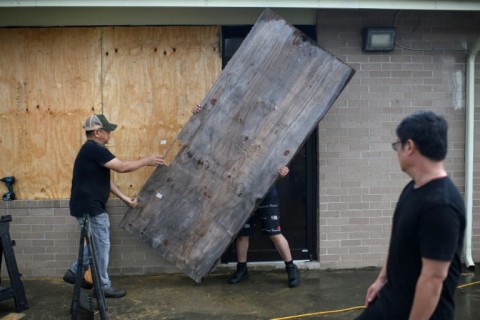 A group of men board up a restaurant in Port Lavaca, Texas, on July 7, 2024, as they prepare for the arrival of Beryl