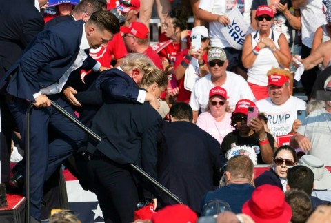 Republican candidate Donald Trump is seen with blood on his face surrounded by Secret Service agents