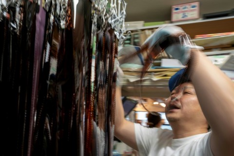 Yoshinobu Ishikawa, representative director of Popeye Camera, checks the finish of colour negatives 