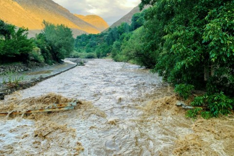 Flash floods gush over a damaged bridge after heavy rainfall in Dara district