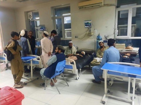 Men sit next to injured children as they receive treatment at a hospital in Jalalabad 